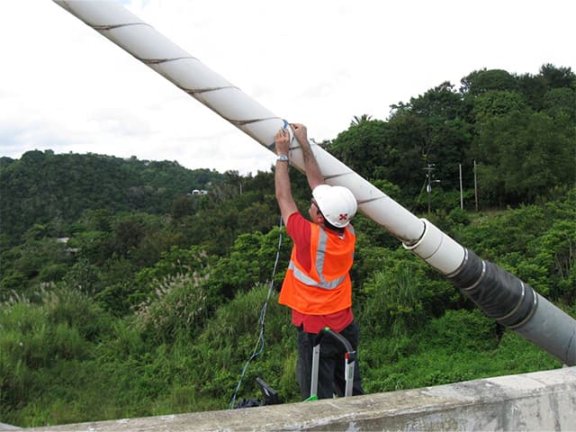Engineer inspecting infrastructure in a wide green valley